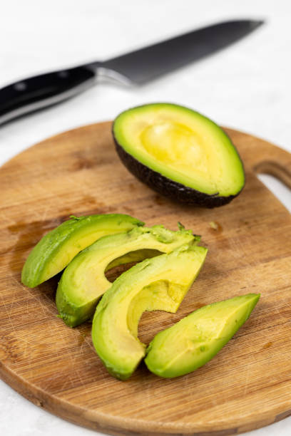 istock Sliced avocado on the round wooden cutting board 1217840798