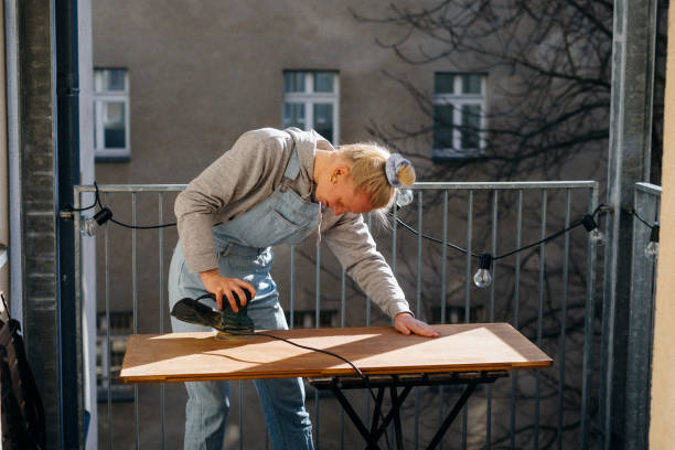 istock Woman fixing a wooden table top 1217841974
