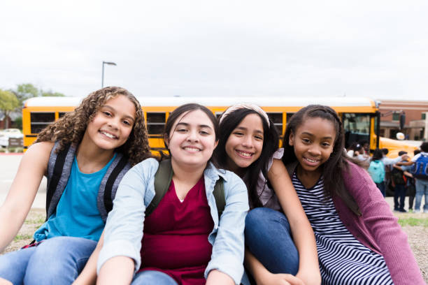 istock Friends smile for camera as they sit together after school 1217842058