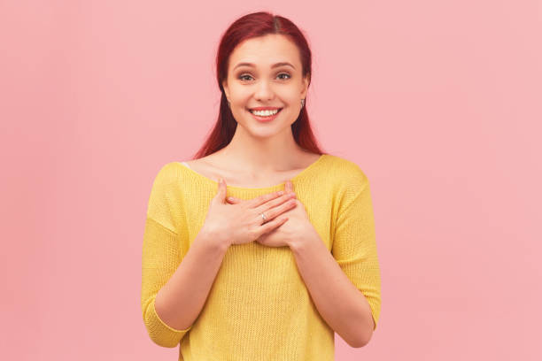istock woman hold hands on chest grateful and touched 1217844646