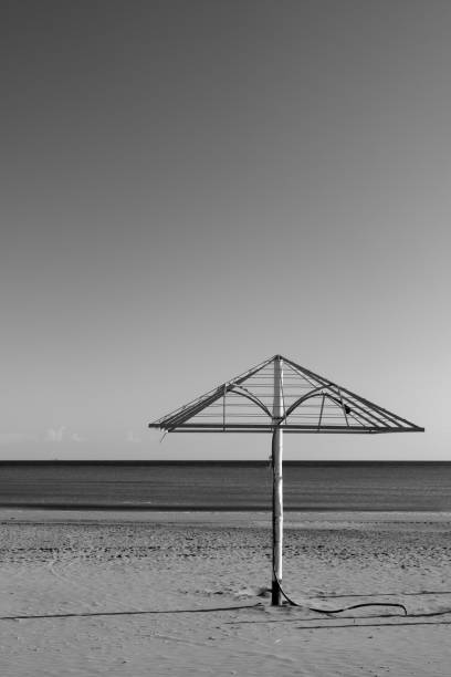 Sea beach with old parasol at off-season, Italy - Minimalistic landscape, black and white photography