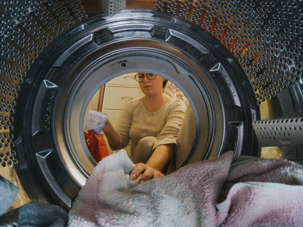 istock Young woman washes laundry 1217847137