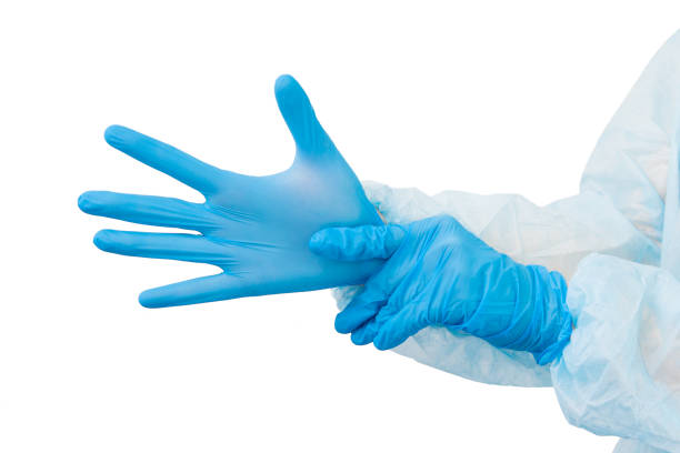 istock Blue medical gloves on hands isolated on white 1217847268