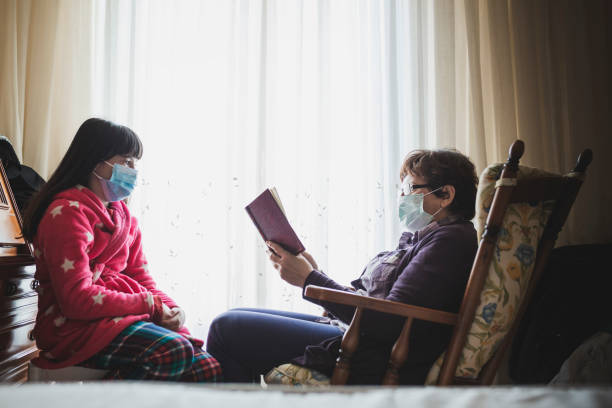 babcia czyta książkę dla swojej małej wnuczki w domu. - grandmother reading child grandson zdjęcia i obrazy z banku zdjęć