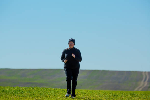 istock Front view of a lady running in a open field. 1217850209