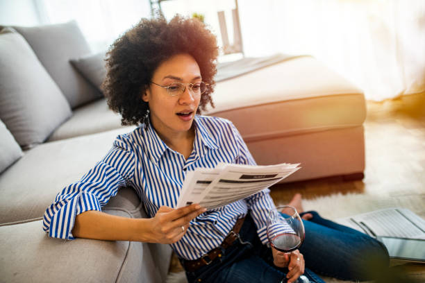 istock Smiling young woman sitting on floor with few reports. 1217850377