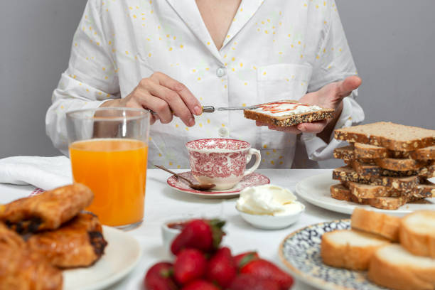 istock Unrecognizable woman having breakfast in pajamas at home in quarantine 1217851479
