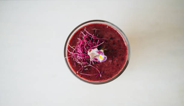 Glass of red smoothie on white background
