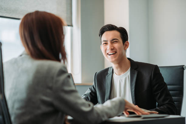 Asian Chinese smiling young businessman having discussion in the meeting room stock photo