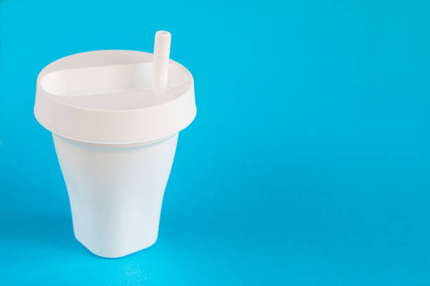 istock White plastic glass with a lid and a straw on a blue background. Disposable tableware for drinks. 1217853395