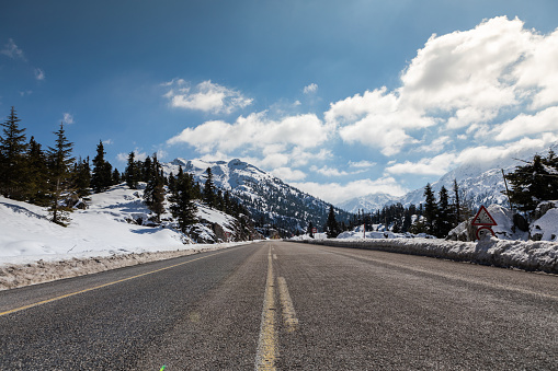 An open mountain road after a fresh dusting of winter time snow.