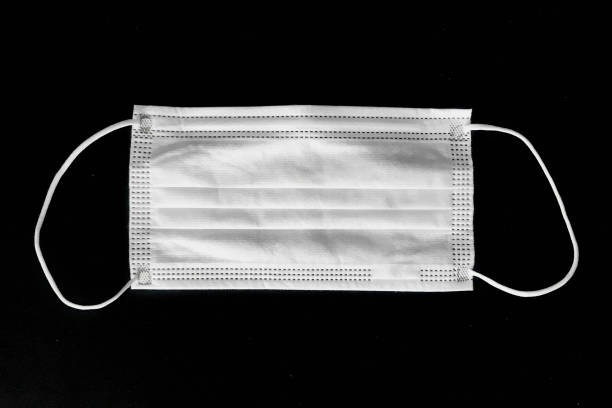 istock Disposable surgical mask on black background 1217855067