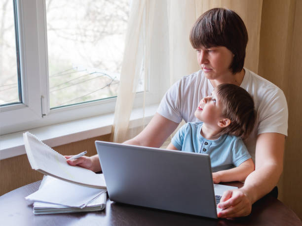 istock Self-isolation because of coronavirus outbreak. Man is remote working with his little son on self quarantine. Lockdown indoors. 1217856141