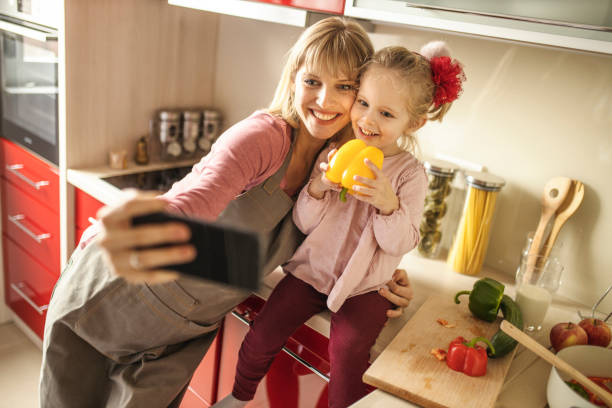 istock Mother and daughter preparing and taking a selfie by mobile phone 1217859155