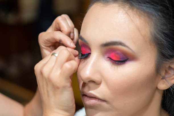istock Makeup artist applying false eyelash.Make up artist doing professional make up of beautiful young woman. 1217859256