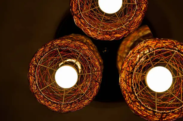 Three light bulbs in a chandelier glowing in the dark