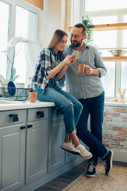 istock Smiling man with coffee looking at girlfriend stock photo 1217860969
