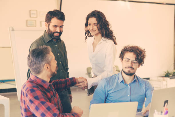 istock Startup leader welcoming female coworker with handshake 1217861104