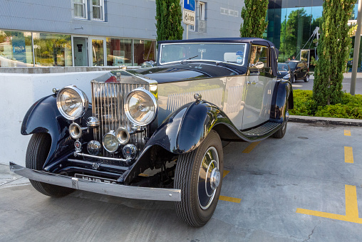 A antique car of Rolls Royce parked on a parking lot at dusk in Dubrovnik, Croatia.