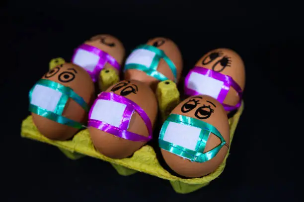 Easter eggs with medical masks. Quarantine concept for Easter holiday due to Coronavirus epidemic