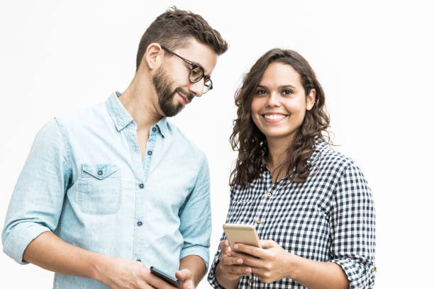 istock Smiling curious guy in glasses looking at girlfriend cellphone 1217862965