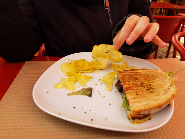 istock Woman eating toast and potato chips 1217862990