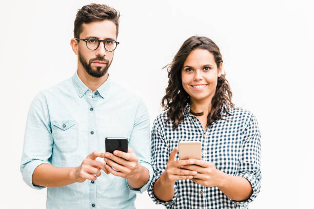 istock Couple standing close together and using smartphones 1217863350
