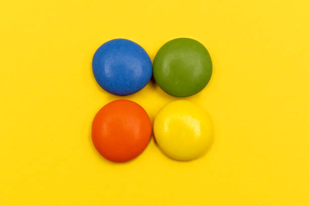 istock Colourful chocolate bean candies on yellow background 1217864714