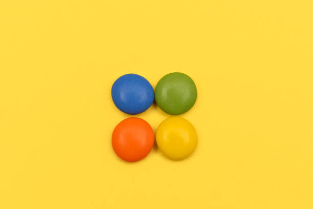 istock Colourful chocolate bean candies on yellow background 1217864769