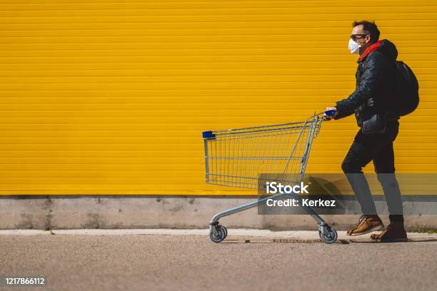 Man With With A Shopping Cart In Front Of A Store Wearing A Mask During A Coronavirus Pandemic Covid19 Stock Photo - Download Image Now