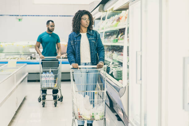 istock Multiethnic customers walking along isles in grocery store 1217866146