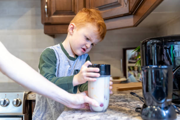 istock Cute kid helping his mother making a smoothie in the kitchen 1217866166