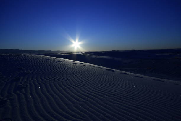 schöne sanddünen, die sich über den horizont erstrecken, während ein wunderschöner idyllischer sonnenaufgang mit sonnenstrahlen gegen klar blauen lebhaften himmel - new mexico landscape sky ethereal stock-fotos und bilder