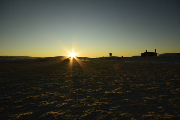 schöne sanddünen, die sich über den horizont erstrecken, während ein wunderschöner idyllischer sonnenaufgang mit sonnenstrahlen gegen klaren bunten lebendigen himmel - new mexico landscape sky ethereal stock-fotos und bilder