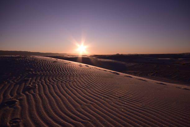 belles dunes de sable s’étendant au-dessus de l’horizon pendant un beau lever de soleil idyllique contre le ciel vif clair - new mexico landscape sky ethereal photos et images de collection