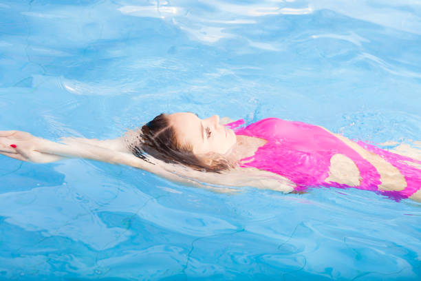 hermosa mujer nadando en la piscina - swimming exercising women back fotografías e imágenes de stock