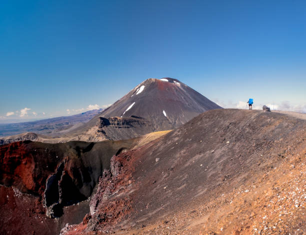 backpacker regardant le mont ngauruhoe (alias mt doom) et red crater dans le parc national de tongariro en nouvelle-zélande. - tongariro crossing photos et images de collection