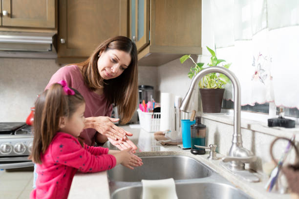 istock Mom teaching daughter how to wash hands 1217869326