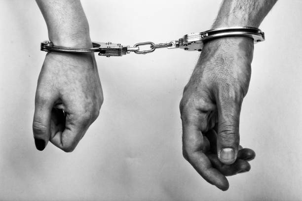 istock men and women cuffed hands together 1217871814