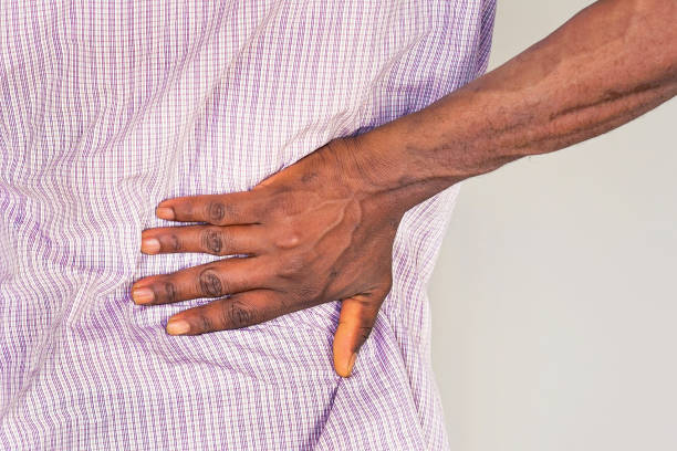 istock African man, pain at lower back. 1217872621