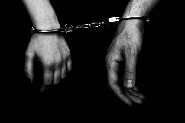 istock men and women cuffed hands together 1217872772