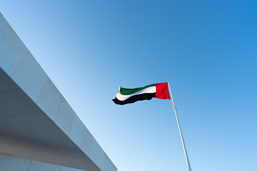 Las banderas de los Emiratos Arabes Unidos ondean contra el hermoso cielo azul photo