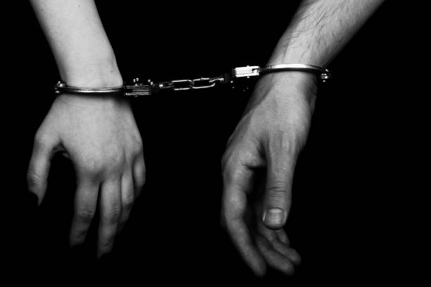 istock men and women cuffed hands together 1217872931