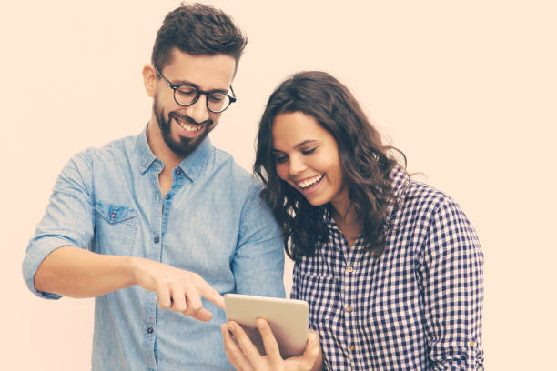 istock Cheerful couple watching content on tablet and laughing 1217873392