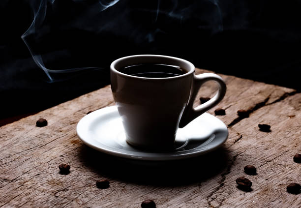 istock Cup with hot coffee on rustic wooden background with coffee beans 1217874520