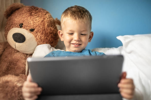 istock Happy little boy toddler at home watching video learning on tablet. 1217874600