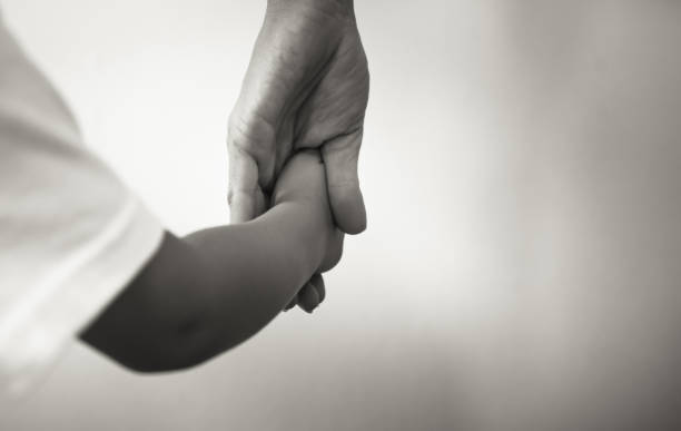 istock Little child holding mothers hand closeup. 1217874611