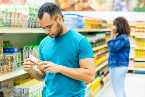 istock Focused African American man reading information on packaging 1217874652