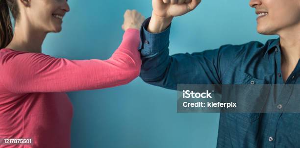 Elbow Bump Greeting To Avoid The Spread Of Coronavirus Two People Friends Greet By Bumping Elbows Instead Of Greeting With A Hug Or Handshake Stock Photo - Download Image Now