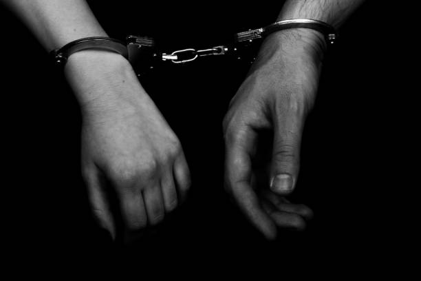 istock men and women cuffed hands together 1217875509